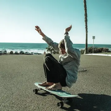 A guy riding a Carver board on the boulevard
