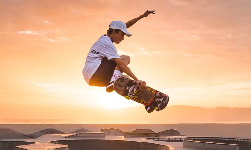 Skateboarder vliegt hoog over de pool van Venice Beach