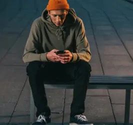 Guy sitting on a bench wearing skate fashion