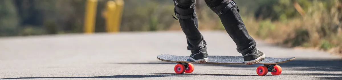 Man rijdt op Orangatang-wielen op zijn longboard